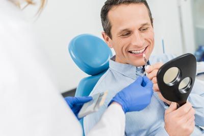 man choosing a shade of dental veneers for his upcoming procedure